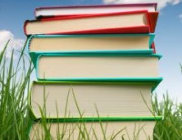 Colourful stack of hardback books in the grass