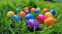 Decorative images, shiny wrapped Easter eggs scattered on grass