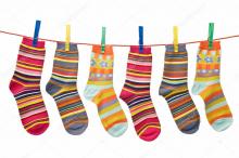 Multicoloured odd stripy socks on a washing line  