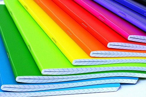 Notebooks in rainbow colours fanned out so all colours can be seen